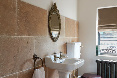 Photo of a bathroom in Other with brown tiles and travertine tiles.