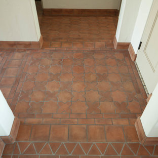 Eklektisk inredning av en liten hall, med beige väggar, klinkergolv i terrakotta och rött golv