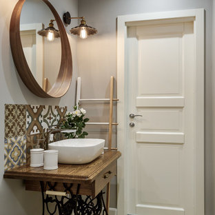 На фото: ванная комната в скандинавском стиле с коричневой плиткой, бежевой плиткой, серыми стенами, настольной раковиной, столешницей из дерева, коричневой столешницей, фасадами цвета дерева среднего тона, фасадами островного типа, светлым паркетным полом, душевой кабиной и бежевым полом с