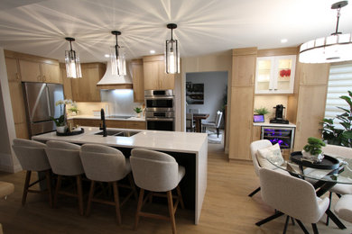 Inspiration for a large contemporary l-shaped vinyl floor and beige floor open concept kitchen remodel in Toronto with an undermount sink, recessed-panel cabinets, beige cabinets, quartz countertops, white backsplash, quartz backsplash, stainless steel appliances, an island and white countertops
