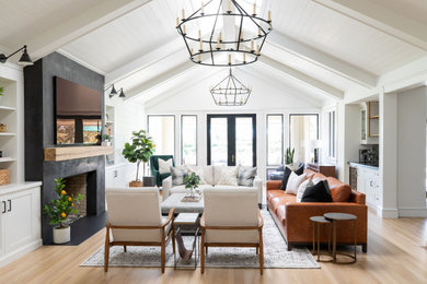 Family room - large cottage open concept light wood floor family room idea in Sacramento with a bar, white walls, a standard fireplace and a wall-mounted tv