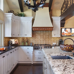 Foto de cocina comedor en L, tradicional, grande, con fregadero bajoencimera, armarios con paneles con relieve, puertas de armario blancas, salpicadero marrón, electrodomésticos de acero inoxidable, suelo de madera oscura, una isla, encimera de granito y salpicadero de azulejos de cerámica