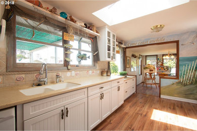 Mid-sized beach style laminate floor and brown floor kitchen photo in Portland