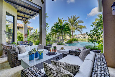 This is an example of a mid-sized contemporary backyard garden in Miami with natural stone pavers.