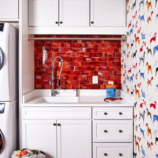 ワシントンD.C.のトラディショナルスタイルのおしゃれなランドリールーム (シングルシンク、シェーカースタイル扉のキャビネット、白いキャビネット、マルチカラーの壁、上下配置の洗濯機・乾燥機、赤い床、白いキッチンカウンター) の写真