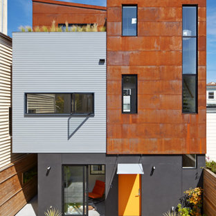 Inspiration för små moderna oranga hus, med tre eller fler plan, metallfasad och pulpettak