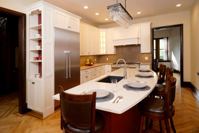 Large elegant l-shaped light wood floor enclosed kitchen photo in Philadelphia with an undermount sink, raised-panel cabinets, white cabinets, quartz countertops, gray backsplash, porcelain backsplash, stainless steel appliances, two islands and white countertops