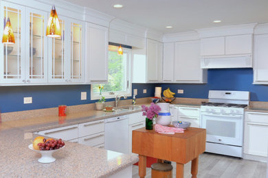 Example of a large classic u-shaped laminate floor and beige floor enclosed kitchen design in Chicago with a double-bowl sink, shaker cabinets, white cabinets, wood countertops, blue backsplash, white appliances and an island