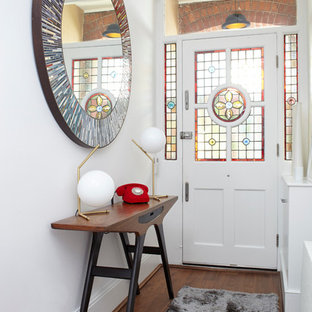 Foto på en eklektisk hall, med vita väggar, mörkt trägolv, en enkeldörr och en vit dörr