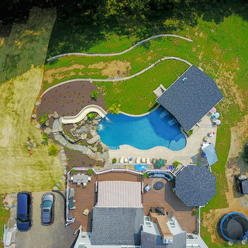 Custom pool with rock waterfalls, water slide & swim up pool bar.