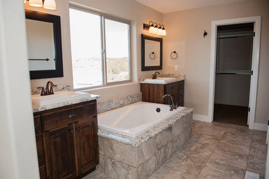 Inspiration for a large country master ceramic tile and single-sink drop-in bathtub remodel in New York with shaker cabinets, dark wood cabinets, beige walls, a drop-in sink and a built-in vanity