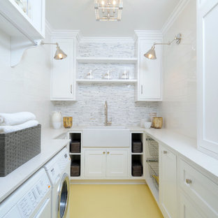 Photo of a medium sized traditional u-shaped separated utility room in Los Angeles with a belfast sink, shaker cabinets, white cabinets, white walls, a side by side washer and dryer, composite countertops and painted wood flooring.