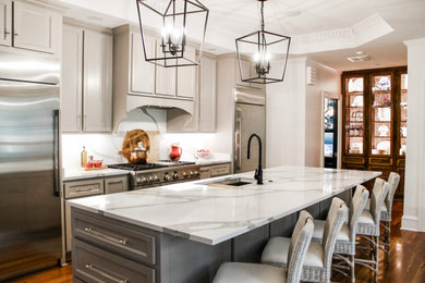 Example of a large minimalist single-wall light wood floor, red floor and tray ceiling eat-in kitchen design in Birmingham with an undermount sink, shaker cabinets, gray cabinets, quartz countertops, white backsplash, quartz backsplash, stainless steel appliances, an island and white countertops