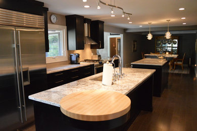 Inspiration for a large transitional u-shaped eat-in kitchen in Milwaukee with an undermount sink, flat-panel cabinets, quartzite benchtops, stainless steel appliances, multiple islands, dark hardwood floors, brown floor, multi-coloured benchtop and dark wood cabinets.