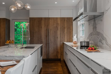 Example of a large eclectic l-shaped dark wood floor and brown floor eat-in kitchen design in Boston with an undermount sink, flat-panel cabinets, white cabinets, solid surface countertops, white backsplash, stone slab backsplash, paneled appliances, two islands and white countertops