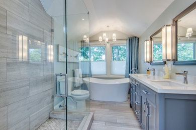 Mid-sized transitional master gray tile and limestone tile limestone floor and gray floor bathroom photo in Toronto with furniture-like cabinets, gray cabinets, a two-piece toilet, gray walls, an undermount sink, quartz countertops and a hinged shower door