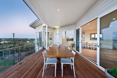 Photo of a beach style balcony in Melbourne with a roof extension.