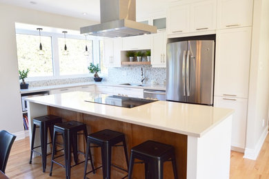 Mid-sized contemporary l-shaped eat-in kitchen in Montreal with an undermount sink, shaker cabinets, white cabinets, quartzite benchtops, white splashback, mosaic tile splashback, stainless steel appliances, light hardwood floors and with island.