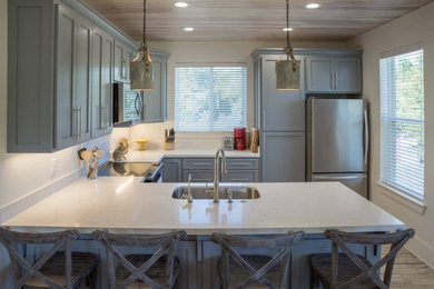 Example of a cottage u-shaped kitchen design in New Orleans with a peninsula