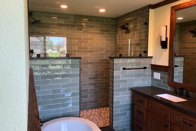 Bathroom - mid-sized craftsman master green tile and ceramic tile travertine floor and beige floor bathroom idea in Minneapolis with flat-panel cabinets, dark wood cabinets, a two-piece toilet, beige walls, an undermount sink, quartz countertops and black countertops