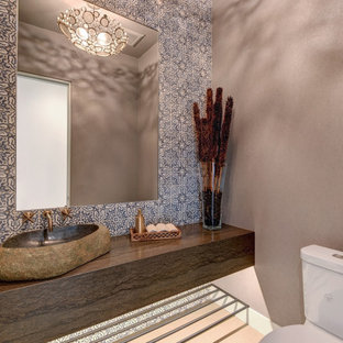 Idées déco pour un WC et toilettes éclectique de taille moyenne avec des portes de placard marrons, un WC séparé, un carrelage bleu, des carreaux en terre cuite, un mur gris, un sol en carrelage de porcelaine, une vasque, un plan de toilette en calcaire, un sol gris, un plan de toilette marron, meuble-lavabo suspendu, un plafond en papier peint et du papier peint.