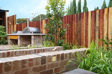 Large country partial sun garden in Sydney with brick pavers.
