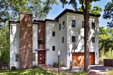 Large trendy white three-story stucco exterior home photo in New York with a mixed material roof