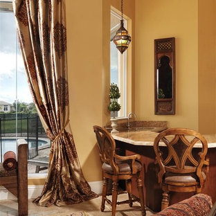 This is an example of a mediterranean living room in Miami with a home bar and yellow walls.