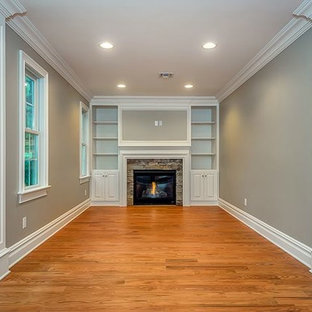 Inspiration for a medium sized modern home studio in New York with grey walls, light hardwood flooring, a standard fireplace and a stone fireplace surround.