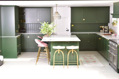 This is an example of a large contemporary kitchen in Essex with shaker cabinets, green cabinets, quartz worktops, an island and white worktops.