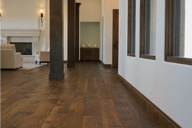 Inspiration for a large rustic dark wood floor and brown floor hallway remodel in Other with white walls