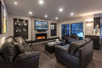 Example of a transitional open concept medium tone wood floor and brown floor living room design in Vancouver with beige walls, a standard fireplace and a tile fireplace