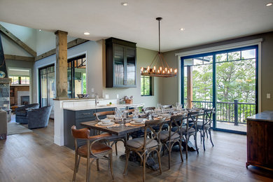 Country dining room in Grand Rapids with beige walls, medium hardwood floors and brown floor.