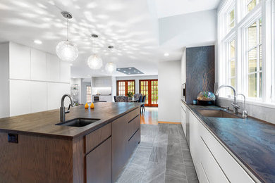 Open concept kitchen - mid-sized contemporary l-shaped open concept kitchen idea in Boston with flat-panel cabinets, white cabinets, quartz countertops and an island