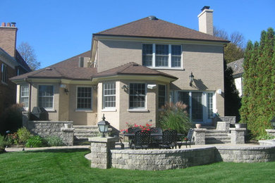 Example of a mid-sized classic beige two-story brick exterior home design in Chicago with a hip roof