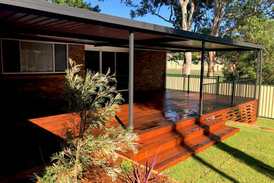 Mid-sized traditional backyard deck in Sydney with a pergola.