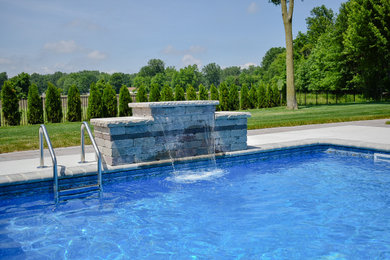 Large backyard brick and rectangular pool fountain photo in Detroit