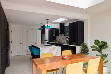 Medium sized contemporary galley kitchen/diner in London with a submerged sink, shaker cabinets, black cabinets, composite countertops, engineered quartz splashback, black appliances, porcelain flooring, an island, grey floors, multicoloured worktops and a drop ceiling.