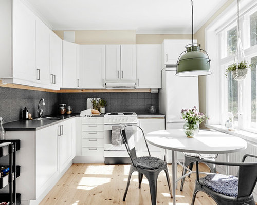 Exempel på ett minimalistiskt kök, med skåp i shakerstil, vita skåp, grått stänkskydd, vita vitvaror, ljust trägolv och beiget golv