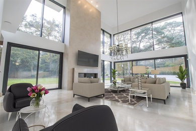Expansive contemporary formal open plan living room in Devon with marble flooring, a wall mounted tv and beige floors.