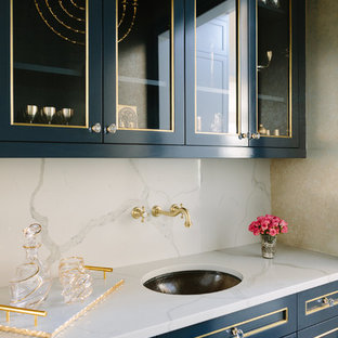 Inspiration för mellanstora klassiska linjära vitt hemmabarer med vask, med en undermonterad diskho, blå skåp, vitt stänkskydd, luckor med glaspanel, marmorbänkskiva och stänkskydd i marmor