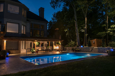 Large contemporary backyard rectangular lap pool in Indianapolis with concrete slab.