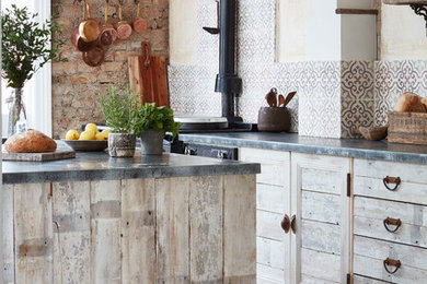 Inspiration for a country open plan kitchen in London with distressed cabinets, multi-coloured splashback, ceramic splashback, black appliances, ceramic floors, with island and multi-coloured floor.