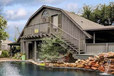 Example of a mountain style two-story wood exterior home design in Houston with a gambrel roof