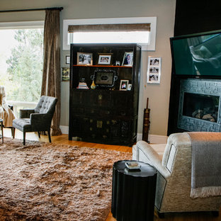 Foto di una grande camera matrimoniale etnica con pareti beige, pavimento in legno massello medio, camino ad angolo e cornice del camino piastrellata