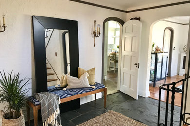 Example of a mid-sized 1950s slate floor and gray floor foyer design in New York with white walls
