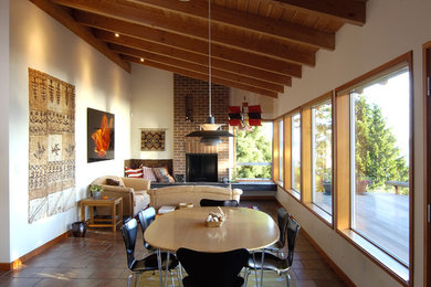 This is an example of a contemporary dining room in Seattle with white walls and brown floor.