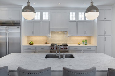 Example of a transitional single-wall eat-in kitchen design in Minneapolis with a single-bowl sink, shaker cabinets, white cabinets, marble countertops, beige backsplash, porcelain backsplash, stainless steel appliances and an island