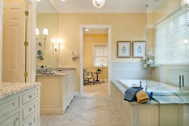 Inspiration for a large traditional master bathroom in Columbus with an undermount sink, beaded inset cabinets, beige cabinets, granite benchtops, a drop-in tub, a corner shower, a two-piece toilet, white tile, ceramic tile, yellow walls and porcelain floors.