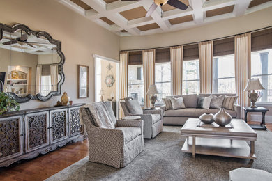 Mid-sized traditional formal enclosed living room in Charlotte with beige walls, medium hardwood floors, a standard fireplace, a plaster fireplace surround, a wall-mounted tv and brown floor.